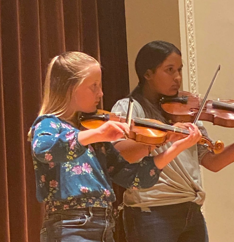 TWO FEMALE STUDENTS PLAYING VIOLINS